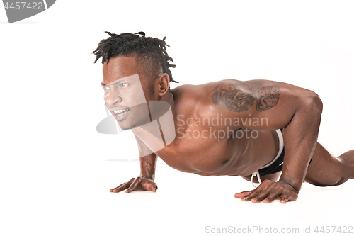 Image of Muscular young man doing press-ups