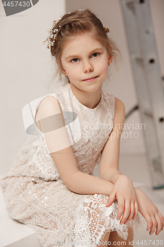 Image of Little pretty girl with flowers dressed in wedding dresses