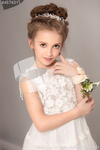 Image of Little pretty girl with flowers dressed in wedding dresses