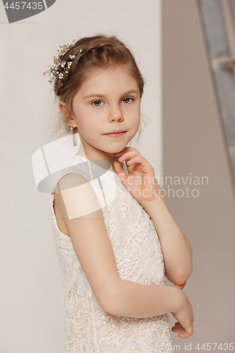 Image of Little pretty girl with flowers dressed in wedding dresses