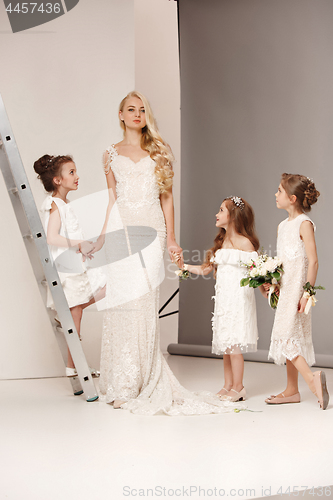 Image of Little pretty girls with flowers dressed in wedding dresses