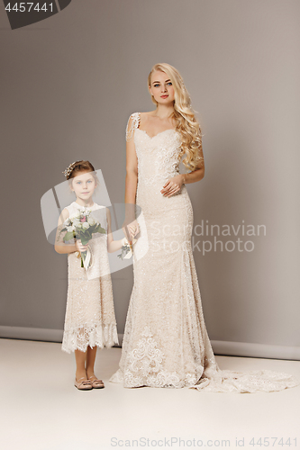 Image of Little pretty girls with flowers dressed in wedding dresses