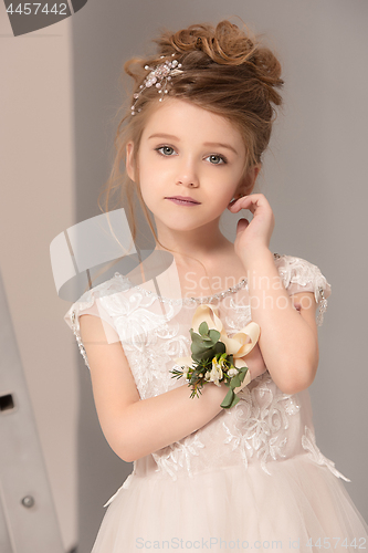 Image of Little pretty girl with flowers dressed in wedding dresses