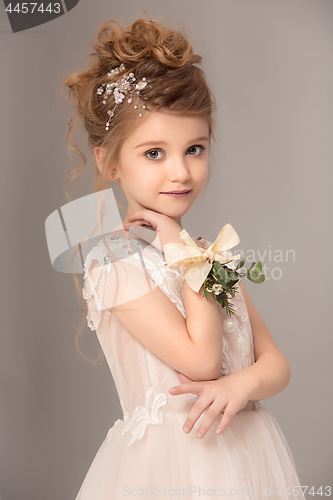 Image of Little pretty girl with flowers dressed in wedding dresses