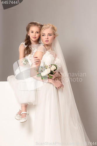 Image of Little pretty girls with flowers dressed in wedding dresses