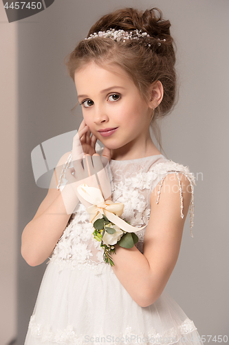 Image of Little pretty girl with flowers dressed in wedding dresses