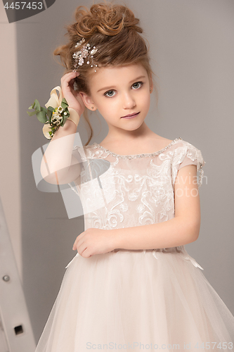 Image of Little pretty girl with flowers dressed in wedding dresses