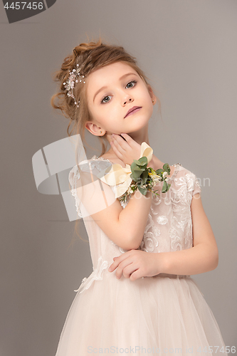 Image of Little pretty girl with flowers dressed in wedding dresses