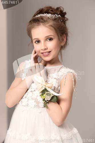 Image of Little pretty girl with flowers dressed in wedding dresses