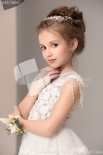 Image of Little pretty girl with flowers dressed in wedding dresses