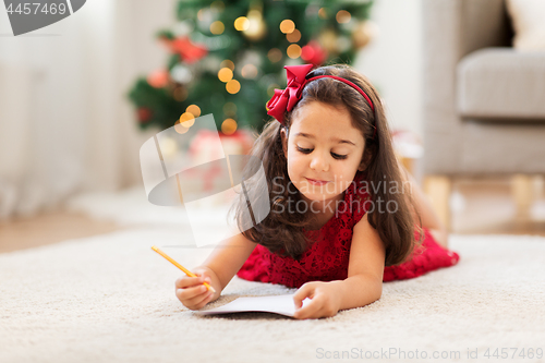 Image of little girl writing christmas wish list at home