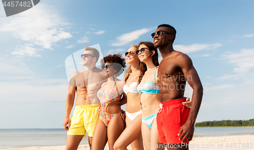 Image of happy friends hugging on summer beach