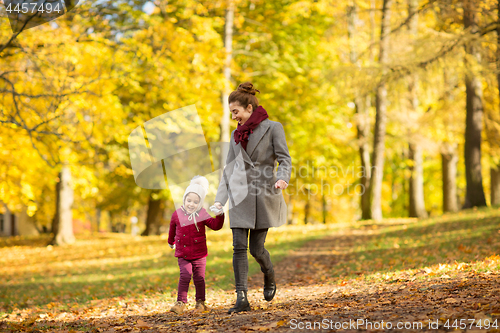 Image of happy mother and little daughter at autumn park