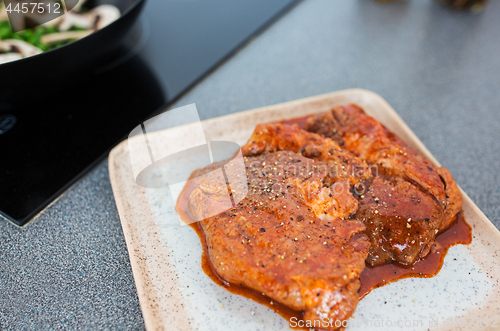 Image of close up of spicy marinated meat on kitchen table