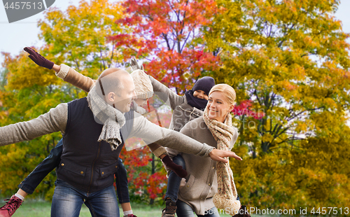 Image of happy family having fun over autumn park