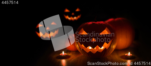 Image of halloween jack-o-lanterns burning in darkness