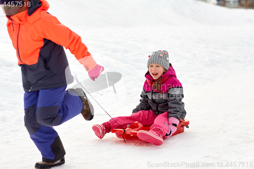 Image of girls with sled having fun outdoors in winter