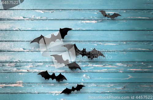 Image of black bats over blue shabby boards background