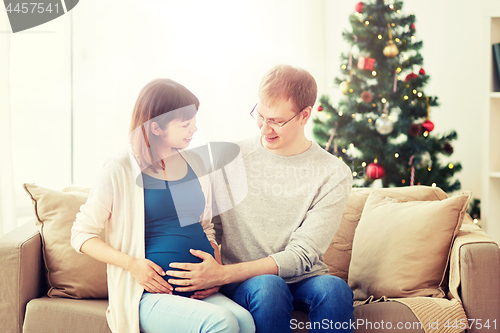 Image of pregnant wife with husband at home at christmas