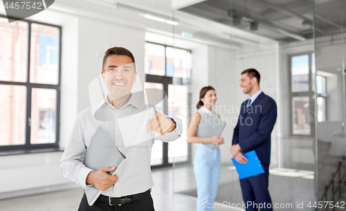 Image of realtor with folder pointing at you at office