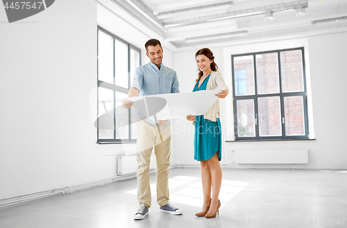 Image of happy couple with blueprint at new home