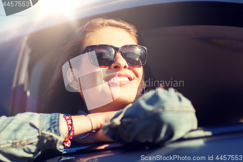 Image of happy teenage girl or young woman in car