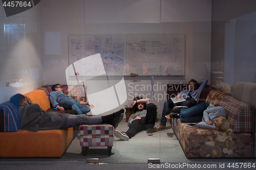 Image of software developers sleeping on sofa in creative startup office