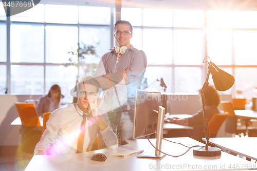 Image of Young businessman helping his colleague at the work