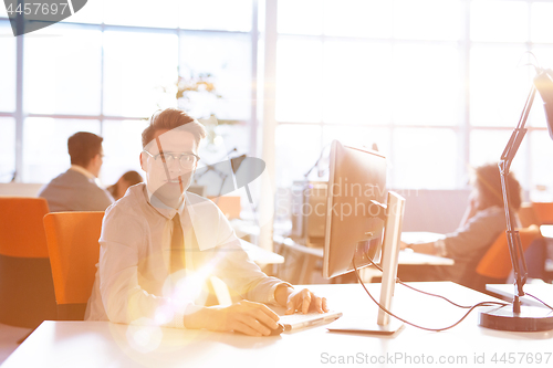 Image of Young businessman using computer at work