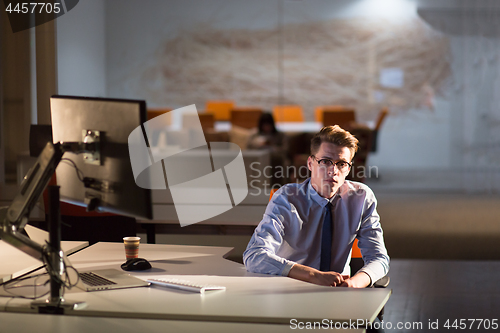 Image of man working on computer in dark office