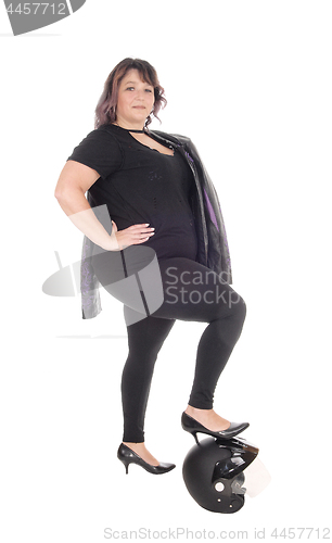 Image of Full size woman standing with leg on helmet
