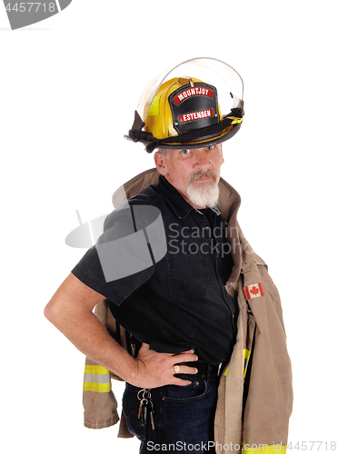 Image of A firefighter standing with his helmet on 