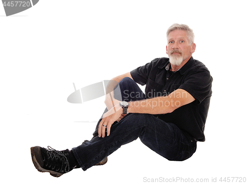 Image of Middle age man sitting on floor