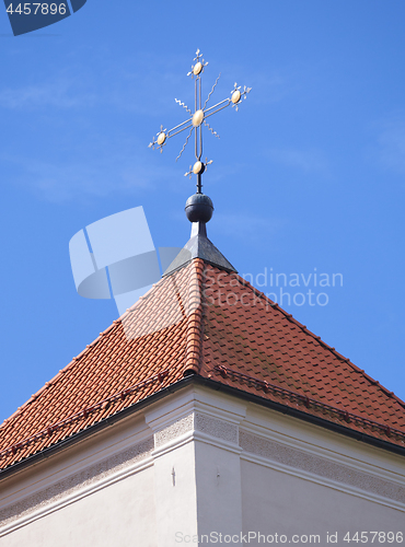 Image of Golden cross on red tile roof