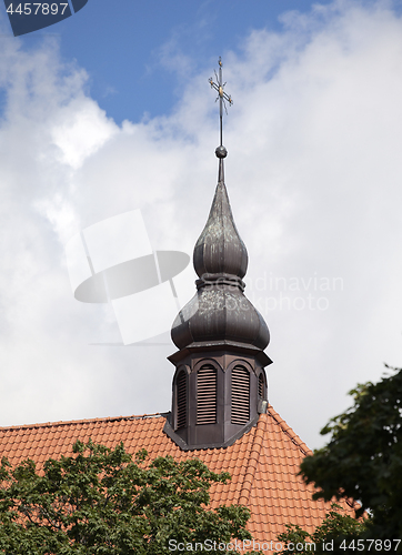 Image of Golden cross on red tile roof