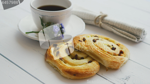 Image of Delicious pastry with raisins and a cup of coffee top view.