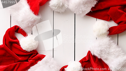 Image of Santa Claus hats on white wooden desk with blank copy space.