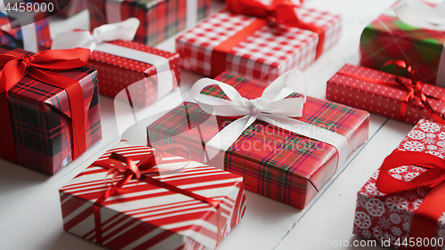 Image of Side view of wrapped Christmas presents laid on the wooden table