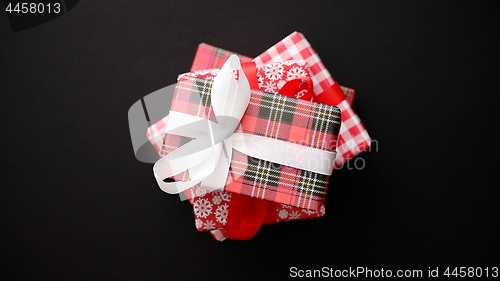 Image of Red gift box with red bow on black table, top view