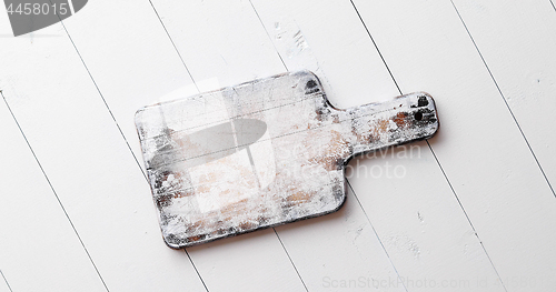 Image of Wooden chopping board on white board table.