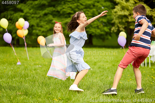 Image of happy kids playing tag game at birthday party