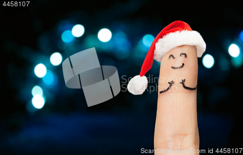 Image of close up of finger in santa hat over lights