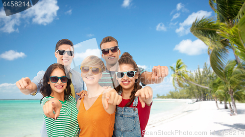 Image of friends in sunglasses pointing at you over beach