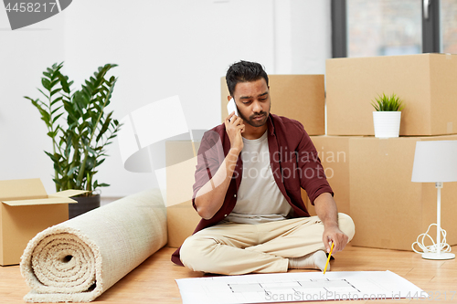 Image of man with blueprint and boxes moving to new home