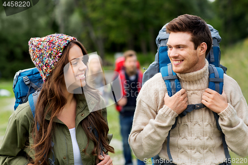 Image of happy friends or travelers with backpacks hiking