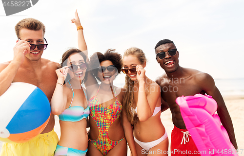 Image of happy friends in sunglasses on summer beach