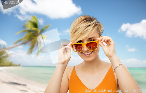 Image of portrait of smiling young woman in sunglasses