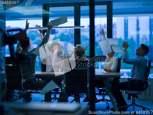 Image of multiethnic Group of young business people throwing documents