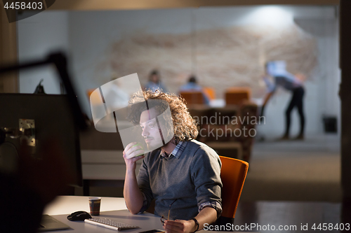 Image of man working on computer in dark office