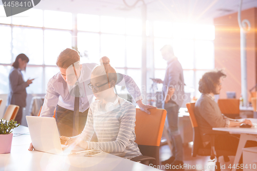 Image of Young businessman helping his colleague at the work